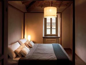 a bedroom with a large bed with a window at Villa in Tuscany with Heated Pool & Sports Court in Poppi