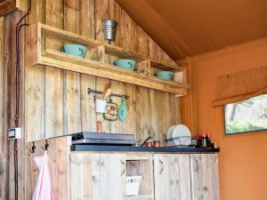 a kitchen with wooden wall with shelves and bowls on it at Glamping Tent in Italy near Adriatic Beaches in Lapedona +11 photos