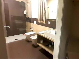 a bathroom with a toilet and a sink and a mirror at Apartment in Iseo with Pool in Cazzago San Martino +21 photos