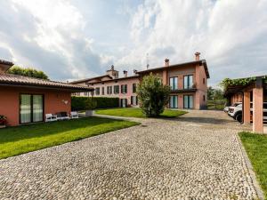 a house with a gravel driveway in front of it at Apartment in Iseo with Pool in Cazzago San Martino