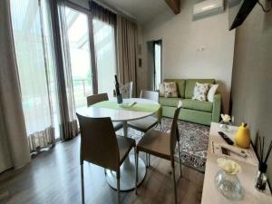 a living room with a table and a green couch at Apartment in Iseo with Pool in Cazzago San Martino