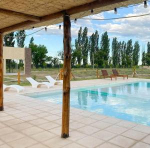 a swimming pool with chairs and a pavilion at Dulces Parrales - Cabañas en San Rafael, Mendoza in San Rafael +22 photos