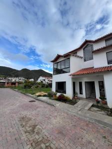 a white house with a brick driveway at Apto Prados de San Jorge #2 in Guatavita +14 photos