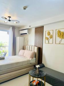 a bedroom with a bed and a side table at Pure Bliss Getaway Condo Near Mactan Airport Lapu-Lapu in Lapu Lapu City +21 photos