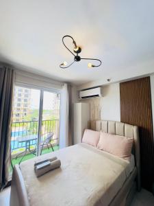 a bedroom with a large bed with a balcony at Pure Bliss Getaway Condo Near Mactan Airport Lapu-Lapu in Lapu Lapu City