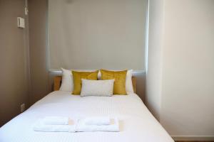een wit bed met 2 kussens erop bij New open 岸里玉出 Maison Le Jaune 玉子心斋桥道顿崛电车直达 in Osaka