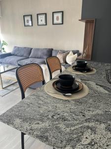 un salon avec une table avec deux bols dessus dans l'établissement Acogedor departamento en solares zona real, alberca, gym y terrazas, à Guadalajara