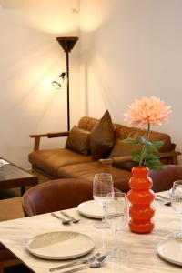 een tafel met glazen en een vaas met een bloem bij New open 岸里玉出 Maison Le Jaune 玉子心斋桥道顿崛电车直达 in Osaka