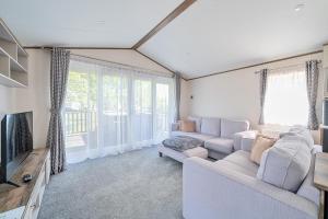 Una sala de estar con un sofá y un televisor. en Wave Whisperers - Hayling Island, en South Hayling