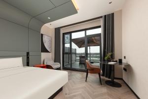 Atour S Hotel Suzhou Jinji Lake Moonlight Pier في سوتشو: غرفة فندق بها سرير ومكتب ونافذة +88 صورة