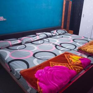 a bed with colorful pillows on top of it at Sai Homestay in Kanchipuram