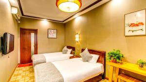 Ένα ή περισσότερα κρεβάτια σε δωμάτιο στο Pingyao Xinglongyi Inn