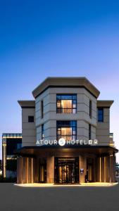 Atour S Hotel Suzhou Jinji Lake Moonlight Pier في سوتشو: منظر أمامي لمبنى دائري يحتوي على فندق جماعي