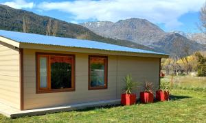 a tiny house with mountains in the background at Cabañas Mi Viejo in El Hoyo +13 photos