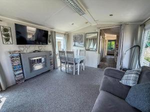 a living room with a couch and a table and a television at Lovely Wheelchair Friendly Caravan At Skipsea Sands In Yorkshire Ref 41167Wf in Barmston