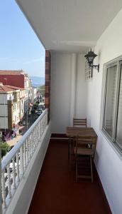a balcony with a table and a view of a city at Cangas centro en familia con encanto in Cangas de Morrazo