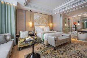a hotel room with a bed and a couch and a table at InterContinental Phuket Resort by IHG in Kamala Beach