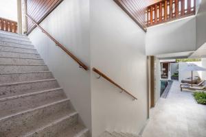 a staircase in a house with white walls and wooden ceilings at InterContinental Phuket Resort by IHG in Kamala Beach