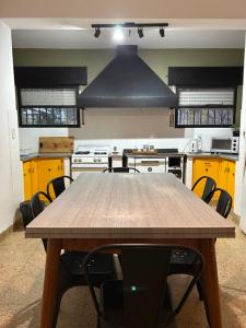 a kitchen with a wooden table and some yellow cabinets at Casa de campo frente al río Colorado in Río Colorado