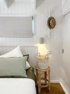 a bedroom with a bed and a hat and a stool at Banjos Cabin Gippsland - Luxury Eco Stay w King Bed & Pond Valley Views in Seaton