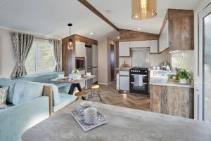 a kitchen and living room with a blue couch at Island Breeze - Hayling Island in South Hayling