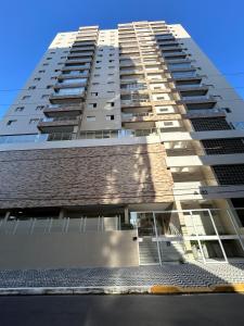 Apartamento Canto do Forte في برايا جراندي: عمارة سكنية طويلة مع السماء في الخلفية