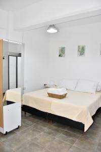 a white bedroom with two beds and a mirror at Departamento en Planta baja, centrico, cochera cubierta Sarmiento265apart D6 in San Fernando del Valle de Catamarca