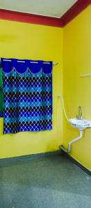 a yellow bathroom with a sink and a window at Sai homestay first floor apartment in Kanchipuram