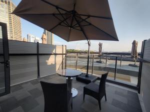 Atour S Hotel Suzhou Jinji Lake Moonlight Pier في سوتشو: طاولة وكراسي ومظلة على السطح