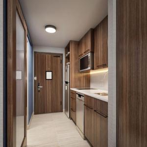 a kitchen with wooden cabinets and a door to a hallway at Homewood Suites By Hilton Saltillo in Saltillo