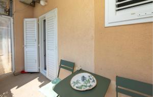 une table et des chaises vertes avec une plaque de cuisson dans l'établissement Nice Apartment In Podgora With Wifi, 