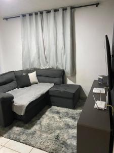 a living room with a couch and a window at Apto Completo com Cozinha Equipada in Valparaíso de Goiás