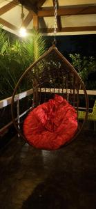 a red pillow sitting in a swinging chair at Gulmohar Villa tamhini ghat, Kolad Rafting 