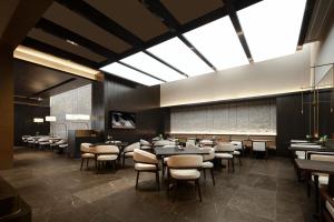 Atour S Hotel Suzhou Jinji Lake Moonlight Pier في سوتشو: مطعم بطاولات وكراسي ونافذة كبيرة