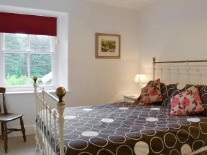 a bedroom with a large bed and a window at Roundhill Cottages 1 in Grasmere