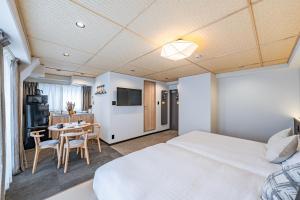 a hotel room with a bed and a table and chairs at Apartment Hotel 11 Yasaka in Kyoto