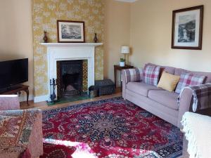 a living room with a couch and a fireplace at Squirrel Cottage in Thornton Dale