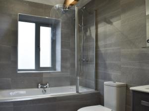 ein Badezimmer mit Dusche und Toilette und einem Fenster in der Unterkunft The Cottage in Bewdley