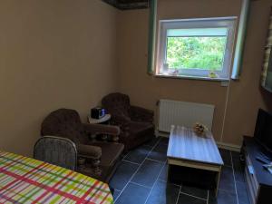 een kamer met stoelen, een tafel en een raam bij Ferienhaus Waldperle Harzblick in Wernrode