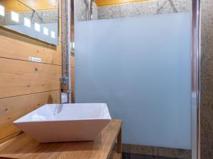 a bathroom with a white sink on a wooden counter at Chalet typiquement franc-comtois avec Wifi et cheminée à Étobon - FR-1-583-405 in Étobon