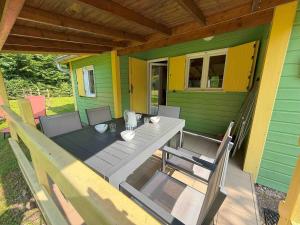a porch with a table and chairs on a house at Chalet paisible pour 6 personnes au cœur de la nature - FR-1-583-419 in Mélisey
