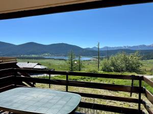 a table on a balcony with a view of the mountains at Appartement T4 Duplex 60m², 6 Pers, Vue Lac & Montagnes - FR-1-758-40 in Les Angles