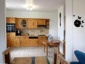 a kitchen with wooden cabinets and a table at Appartement rénové 3 chambres à Luxeuil-les-Bains - FR-1-583-398 in Luxeuil-les-Bains
