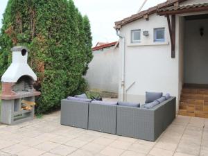 a patio with a couch and an outdoor oven at Appartement rénové 3 chambres à Luxeuil-les-Bains - FR-1-583-398 in Luxeuil-les-Bains