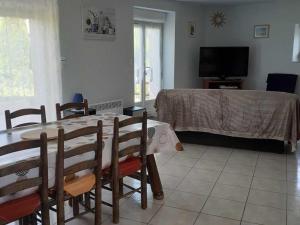 a living room with a table and a television at Gîte paisible en campagne proche nature - FR-1-583-408 in La Villedieu-en-Fontenette