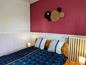 une chambre avec un lit et un mur rouge dans l'établissement Appartement charmant au pied du Plateau des Mille Etangs à Mélisey - FR-1-583-425, à Mélisey
