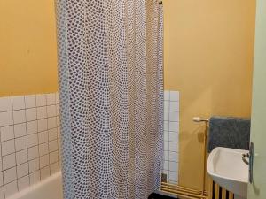 une salle de bain avec un rideau de douche et un lavabo dans l'établissement Appartement charmant au pied du Plateau des Mille Etangs à Mélisey - FR-1-583-425, à Mélisey 11 autres photos