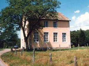une vieille maison avec un arbre dans un champ dans l'établissement Appartement charmant au pied du Plateau des Mille Etangs à Mélisey - FR-1-583-425, à Mélisey