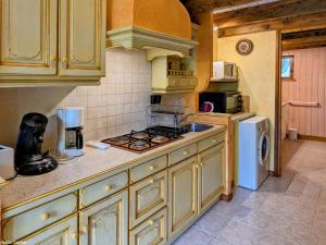 a kitchen with a stove and a refrigerator at Charmante maison en pierre au cœur des Vosges - FR-1-583-436 in Saint-Bresson