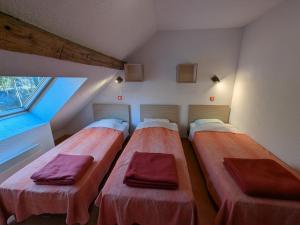 three beds sitting in a room with a window at Gîte Le Séquoia: Confort pour 17 personnes, idéal pour randonner dans les Vosges Saônoises - FR-1-583-426 in Clairegoutte